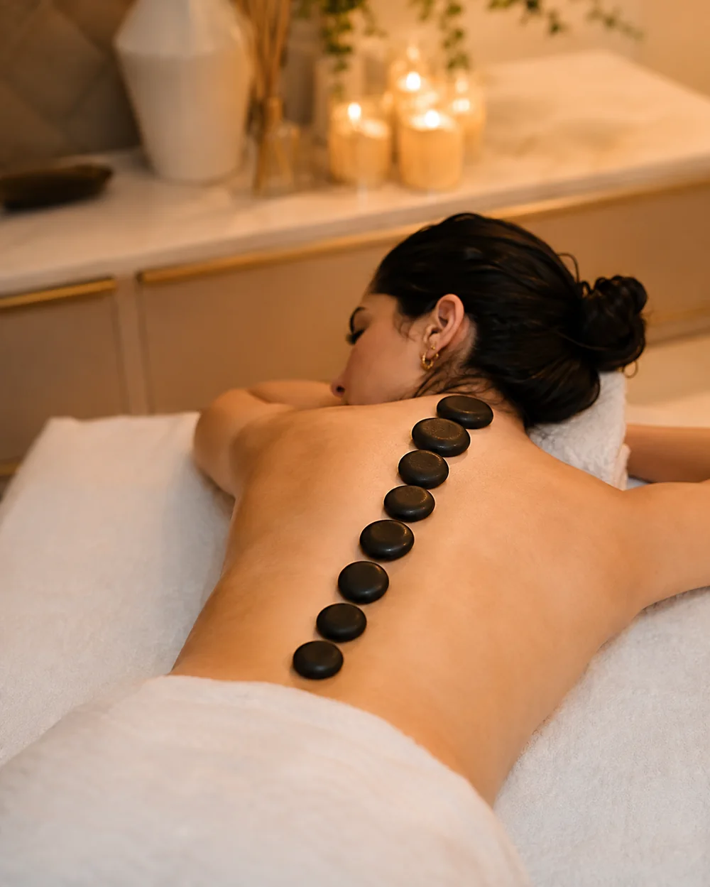 Pedras de basalto quentes alinhadas nas costas durante massagem relaxante